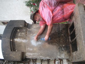 Kelly getting water from the Year of our Lord 1917 fountain. It was the only day of rain that we had. 